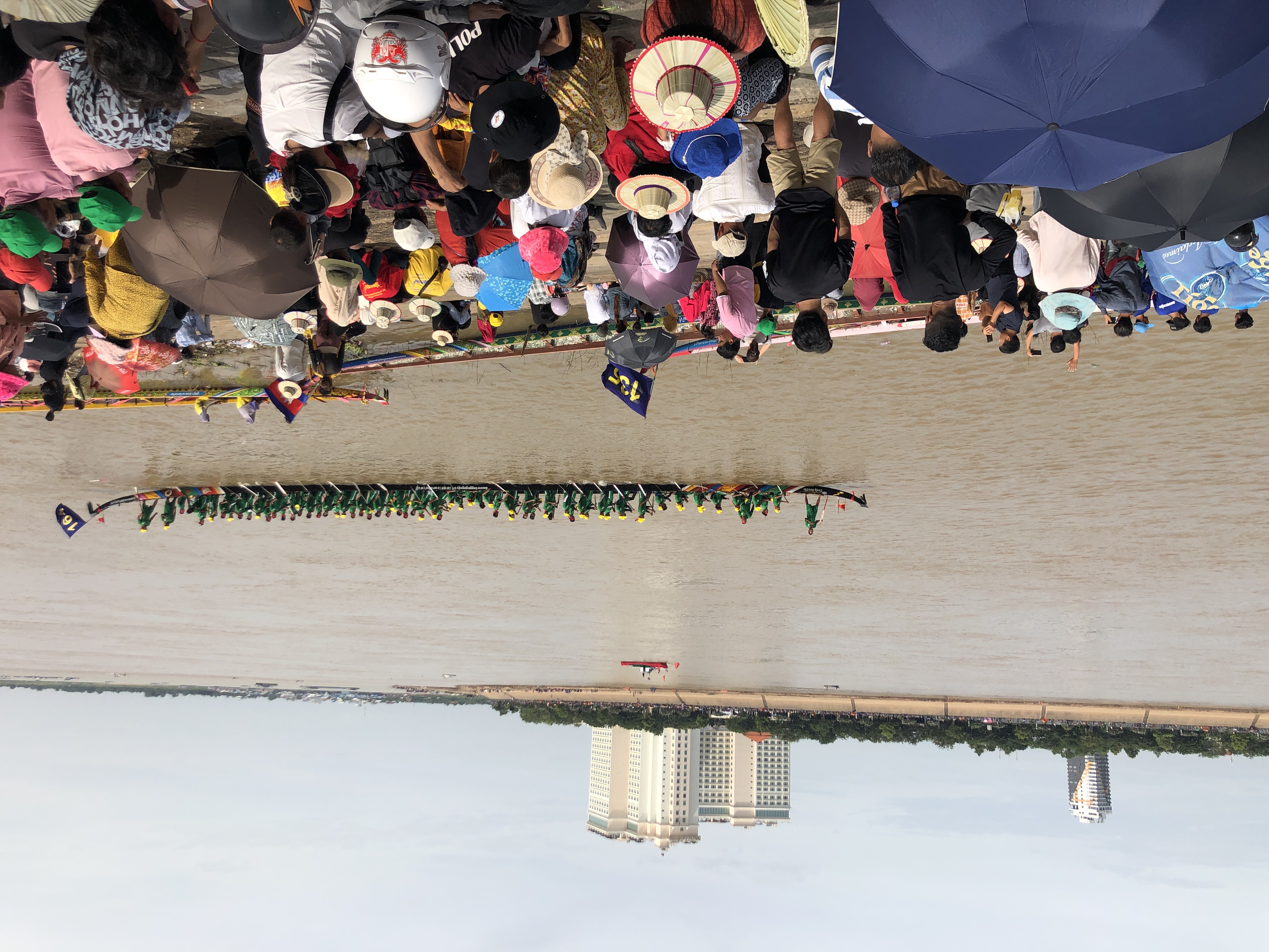 A longboat crew and spectators on the Tonlé Sap riverbanks during the Water Festival in Phnom Penh, November 2023